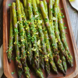 Lemon garlic roasted asparagus is a simple yet tasty dish. It takes just 25 minutes to make. This recipe serves four people. You can enjoy it as a side dish with any meal. To make this dish, gather these items: - 1 lb fresh asparagus, trimmed - 3 tablespoons extra virgin olive oil - 3 cloves garlic, finely minced - Zest of 1 medium lemon - Juice of 1 medium lemon - 1 teaspoon sea salt - ½ teaspoon freshly ground black pepper - ¼ teaspoon red pepper flakes (optional, for a spicy kick) - Fresh parsley, finely chopped for garnish Each ingredient plays an important role. The olive oil adds richness. Garlic gives a strong flavor. Lemon zest and juice add brightness. The seasonings bring everything together. You will need a few simple tools for this recipe: - A large mixing bowl - A whisk or fork for mixing - Tongs or your hands for tossing - A baking sheet - Parchment paper for easy cleanup These tools help you prepare and cook the asparagus easily. Once you have everything, you can make this dish quickly and enjoy its fresh flavors! First, preheat your oven to 425°F (220°C). This high temperature helps the asparagus roast evenly. While the oven heats up, trim the tough ends off the asparagus. You want fresh, bright green spears for the best taste. Place them aside, ready for the next step. In a large mixing bowl, pour 3 tablespoons of extra virgin olive oil. Add 3 finely minced cloves of garlic. Next, zest one medium lemon and squeeze in the juice from the same lemon. Now, sprinkle in 1 teaspoon of sea salt, ½ teaspoon of black pepper, and a pinch of red pepper flakes if you like heat. Whisk this mix well until it smells amazing and all the flavors blend together. Take your trimmed asparagus and place it into the bowl with the lemon garlic mixture. Use tongs or your hands to toss the asparagus gently. Make sure every spear gets coated well. Next, line a baking sheet with parchment paper for easy cleanup. Spread the coated asparagus in a single layer on the sheet. Now, place the baking sheet in your preheated oven. Roast the asparagus for 12-15 minutes. Look for a tender texture and a slight caramelization for the best flavor. When done, carefully take the baking sheet out and let it cool for a few minutes. Finally, transfer the asparagus to a serving platter and sprinkle some chopped parsley on top for a fresh touch. For more details, check out the Full Recipe. To get the best results, start with fresh asparagus. Look for bright green stalks with firm tips. Trim the ends to remove the tough parts. Spread the asparagus in a single layer on your baking sheet. This helps them roast evenly. Avoid crowding the pan; give them space to brown. Roast them at 425°F for a crispy texture, about 12-15 minutes. Keep an eye on them for that nice golden color! Garnishes can make your dish pop! After roasting, sprinkle chopped parsley on top. It adds a fresh taste and bright color. You can also try adding grated Parmesan cheese for a rich touch. For a citrusy kick, add extra lemon zest just before serving. These simple additions can elevate your dish and impress your guests! Want some heat? Add red pepper flakes to the lemon garlic mix. Start with a little, then taste. You can always add more if you like it spicier! If you prefer a milder dish, skip the red pepper flakes. Adjusting spiciness allows you to customize the recipe to your taste. Enjoy experimenting until you find your perfect balance! {{image_4}} You can make this dish even better by adding more veggies. Carrots and bell peppers work well. Simply cut them into sticks. Toss them with the asparagus in the lemon garlic mix. You can roast them all together. This adds color and crunch to your dish. Herbs can change the flavor of your roasted asparagus. Try using fresh thyme or rosemary. Chop them finely and mix them in with the lemon garlic coating. Basil also pairs nicely. Each herb brings its own taste to the dish, making it unique. Roasting is great, but you can try other methods too. Grilling gives a smoky flavor. Just toss the asparagus on a hot grill for a few minutes. You can also steam them for a lighter option. Steamed asparagus stays bright green and tender. Each method offers a new way to enjoy this tasty dish. After enjoying your lemon garlic roasted asparagus, store any leftovers in an airtight container. This keeps the asparagus fresh for up to three days. Place the container in the fridge to maintain the best flavor and texture. Avoid leaving it out at room temperature, as this can spoil the dish quickly. To reheat the asparagus, use your oven or a skillet. Preheat your oven to 350°F (175°C). Lay the asparagus on a baking sheet and warm for about 10 minutes. If using a skillet, add a splash of olive oil and heat over medium heat for about 5 minutes. This method keeps the asparagus tender and flavorful. Freezing roasted asparagus is an option, but note that it may lose some texture. To freeze, let the asparagus cool completely. Then, place it in a single layer on a baking sheet and freeze for 1-2 hours. Once frozen, transfer it to a freezer bag. This way, you can enjoy lemon garlic roasted asparagus later, but be mindful that reheating may change its texture. For the full recipe, check the details above. Yes, you can use frozen asparagus. However, fresh asparagus tastes better. Frozen asparagus may become soft when cooked. If using frozen, roast for a shorter time. Check it often to avoid mushiness. Lemon Garlic Roasted Asparagus pairs well with many dishes. Here are some great options: - Grilled chicken or fish - Quinoa or rice - Pasta with lemon sauce - A fresh salad These sides balance the flavors and make a complete meal. When picking fresh asparagus, look for firm, straight stalks. The tips should be closed and bright green. Avoid stalks that are limp or have brown spots. If you can, smell the ends. Fresh asparagus has a slight earthy scent. This blog post covered how to make Lemon Garlic Roasted Asparagus. We looked at the key ingredients, tools, and step-by-step cooking instructions. I shared tips for perfect roasting and ways to enhance flavor. You can also explore variations with other veggies and herbs. Lastly, I included storage tips to keep leftovers fresh. Try this recipe for a tasty side dish. Enjoy the bright flavors and health benefits of asparagus in every bite.