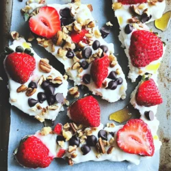 - 2 cups plain Greek yogurt - 2 tablespoons honey or maple syrup - 1 teaspoon pure vanilla extract - 1 cup fresh strawberries - ¼ cup dark chocolate chips - 2 tablespoons chopped nuts The main ingredients make this Frozen Yogurt Strawberry Bark fresh and tasty. You start with Greek yogurt. It offers a thick base and a good dose of protein. Honey or maple syrup adds the right sweetness. I love using pure vanilla extract to enhance the flavor. Fresh strawberries bring a burst of juicy goodness. Dark chocolate chips add a rich touch, while chopped nuts give a nice crunch. - Alternative sweeteners: You can swap honey for agave syrup or stevia. Both work well and keep it sweet. - Dairy-free yogurt options: Use coconut yogurt or almond yogurt for a great dairy-free choice. - Fresh vs. frozen strawberries: Fresh strawberries taste best, but you can use frozen if that's what you have. Just thaw them first for easier mixing. These substitutions help you customize the recipe. So, make it your own! For the full recipe, check the detailed instructions and tips. To start, we need to create a creamy yogurt mix. First, grab a medium mixing bowl. Add 2 cups of plain Greek yogurt. Then, pour in 2 tablespoons of honey or maple syrup. This sweetens the mix just right. Next, add 1 teaspoon of pure vanilla extract. Whisk these together until the mixture is smooth. You want it to be completely blended. The smoother it is, the better it spreads later. Now, it's time to assemble our bark. Line a baking sheet with parchment paper or a silicone mat. This step helps the yogurt not stick. Once lined, carefully pour the yogurt mixture onto the sheet. Use a spatula to spread it out. Aim for a rectangle about ½ inch thick. It should look even. Next, take 1 cup of fresh strawberries and slice them. Distribute these over the yogurt mix. Press them down gently so they stick. Then, sprinkle ¼ cup of dark chocolate chips and 2 tablespoons of chopped nuts on top. This adds nice flavor and crunch. Let’s freeze our creation! Place the baking sheet in the freezer. Wait about 4 to 6 hours. You want the yogurt bark to become solid. Once frozen, take it out. Break the bark into pieces by hand. For cleaner cuts, you can use a sharp knife. Store the pieces in an airtight container. Keep them in the freezer until you are ready to enjoy. Serve them on a bright plate, and maybe add a drizzle of honey on top for fun. Enjoy this cool treat! To make your frozen yogurt strawberry bark even better, start by adjusting the sweetness. Some like it sweeter, while others prefer less sugar. You can use honey or maple syrup as a sweetener. Just add it slowly and taste as you go. Next, ensure even distribution of ingredients. When spreading the yogurt mixture, use a spatula for an even layer. This helps every bite taste great. Press the strawberries down slightly into the yogurt. This way, they stick and won’t fall off when frozen. When it comes to serving, think bright and colorful. Arrange the yogurt bark pieces on a vibrant plate. You can add fresh strawberries around the edges for a pop of color. Drizzling honey over the top adds a nice touch. This simple step makes the dessert look fancy and inviting. For parties, cut the bark into small pieces. This way, guests can grab a bite easily. You can also use mini cups for each piece. This keeps things neat and fun. One common mistake is sticking to the pan. To prevent this, always line your baking sheet with parchment paper or a silicone mat. This step is key for easy removal. Another mistake is not freezing long enough. The bark needs at least 4 to 6 hours in the freezer. If it’s not frozen solid, it will be hard to break. Wait until it’s firm for the best results. {{image_4}} You can change the flavor of your frozen yogurt strawberry bark easily. Try adding more fruits like bananas or blueberries. These fruits add sweetness and color. You can mix them into the yogurt or layer them on top. You can also use different nuts and seeds. Almonds, walnuts, or even pistachios add crunch. Chia seeds or flaxseeds can boost the health factor. Just sprinkle them on before you freeze the bark. If you need gluten-free options, this recipe is great. All the ingredients are naturally gluten-free. Just make sure to check the labels on your yogurt and chocolate chips. You can also make a vegan version. Use coconut yogurt instead of Greek yogurt. Swap honey for maple syrup to keep it plant-based. These changes keep the bark delicious and friendly for all diets. Think beyond just eating frozen yogurt bark as is. You can use it as a topping for pancakes or waffles. Break it into pieces and sprinkle over your breakfast. Another fun idea is to add it to smoothie bowls. The cool, creamy bark adds texture. Blend your favorite fruits and yogurt, then add the bark on top for a tasty crunch. For the full recipe, check out the main article. Enjoy your tasty treats! To keep your frozen yogurt strawberry bark fresh, use airtight containers. This helps prevent ice crystals and keeps the flavor strong. Make sure to seal the container tightly. Store it in the freezer until you're ready to enjoy it. The cold keeps it firm and tasty. How long does the yogurt bark stay good? If stored well, it can last for about two weeks. To check for spoilage, look for signs like freezer burn or a change in texture. If it feels dry or has an off smell, it's best to toss it. Can you refreeze yogurt bark? Yes, but it may not be as good. Each time you refreeze it, the texture can change. It may become icy and lose some of its creaminess. For the best taste, try to only freeze it once. To make Frozen Yogurt Strawberry Bark, follow these steps: 1. Mix 2 cups of plain Greek yogurt with 2 tablespoons of honey and 1 teaspoon of vanilla. 2. Line a baking sheet with parchment paper. 3. Spread the yogurt mix on the sheet, making a rectangle about ½ inch thick. 4. Add sliced strawberries on top, pressing them in gently. 5. Sprinkle dark chocolate chips and chopped nuts over everything. 6. Freeze for 4 to 6 hours. 7. Once frozen, break into pieces. Enjoy your treat! For the full recipe, check the earlier section. Yes, Frozen Yogurt Strawberry Bark is a healthy treat. It uses Greek yogurt, which is high in protein and calcium. Strawberries add fiber and vitamins. The honey or maple syrup adds natural sweetness but can be adjusted. Keep in mind the sugar content from honey and chocolate chips. This treat is lower in sugar than many desserts. Absolutely! You can switch out strawberries for bananas, blueberries, or raspberries. Each fruit adds its unique flavor. You could also try kiwi or mango for a tropical twist. Mix and match for fun combinations. Just make sure the fruits are fresh and ripe for the best taste. Yes, you can. If you want less sweetness, use less honey or maple syrup. You can also try adding a ripe banana for natural sweetness. If you need more sweetness, add a bit more honey. Just taste as you go to keep the flavor balanced. This article covered how to make delicious frozen yogurt bark with simple ingredients. We shared ingredient swaps, step-by-step instructions, and storage tips. You can customize your bark with different fruits and flavors. Avoid common mistakes for the best results. Remember, this treat is healthy and fun for all. Enjoy your tasty creation!