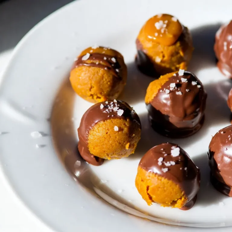 To make these tasty truffles, you will need the following ingredients: - 1 cup pumpkin puree - 1 cup cream cheese, softened - 1 teaspoon pure vanilla extract - 1 teaspoon ground cinnamon - ½ teaspoon ground nutmeg - ½ teaspoon ground ginger - ¼ teaspoon ground cloves - 2 cups graham cracker crumbs - 1 cup caramel sauce, divided - 1 cup semi-sweet chocolate chips - A pinch of sea salt for garnish You can add a few fun things to make your truffles unique. Here are some ideas: - Finely chopped nuts for crunch - Different spices like allspice or cardamom - A splash of maple syrup for extra sweetness - Add a dash of cayenne for a spicy kick If you have dietary needs, you can swap some ingredients. Here are some options: - Use dairy-free cream cheese for a vegan version - Replace graham crackers with gluten-free crumbs - Swap semi-sweet chocolate chips for dark or milk chocolate - Use a sugar-free caramel sauce to lower sugar content This list gives you the basics and some fun options. Enjoy making these truffles your own! {{ingredient_image_2}} To start, grab a large mixing bowl. Add 1 cup of pumpkin puree and 1 cup of softened cream cheese. Then, pour in 1 teaspoon of pure vanilla extract. Next, sprinkle in your spices: 1 teaspoon of ground cinnamon, ½ teaspoon of nutmeg, ½ teaspoon of ginger, and ¼ teaspoon of cloves. Use a hand mixer or whisk to blend these ingredients together. Keep mixing until the mixture is smooth. Take a moment to ensure there are no lumps. Then, take 2 cups of graham cracker crumbs and gradually add them to your pumpkin mix. Gently fold everything together. Your goal is to form a thick dough that holds its shape, but isn’t too sticky. Now it’s time to shape your truffles. Cover the bowl with plastic wrap and pop it into the fridge for about 30 minutes. This helps the mixture firm up. After chilling, scoop out portions with a tablespoon. Roll them into small balls, about 1 inch in diameter, and place them on a parchment-lined tray. Using your finger or the back of a spoon, create a small indentation in each truffle. Carefully fill these indentations with about a teaspoon of caramel sauce. Then, pinch the sides of the dough back together to fully cover the caramel. Once you’ve filled them all, freeze the truffles for at least 15 minutes to help them set. While the truffles are freezing, it’s time to melt the chocolate. Use a microwave-safe bowl and add 1 cup of semi-sweet chocolate chips. Melt the chocolate in 30-second intervals. Stir after each interval until the chocolate is completely smooth. Once melted, take the truffles out of the freezer. Dip each truffle into the warm chocolate, ensuring they’re fully coated. Allow any extra chocolate to drip off before placing them back on the parchment-lined tray. Before the chocolate sets, sprinkle a tiny pinch of sea salt on top of each truffle. This adds a nice flavor contrast. Let them sit at room temperature until the chocolate hardens, or speed it up by placing them in the fridge. Enjoy your truffles as a tasty fall treat! To make sure your truffles stay soft and creamy, follow these steps: - Use fresh pumpkin puree; canned is fine, but fresh gives better flavor. - Soften the cream cheese fully before mixing. This helps create a smooth blend. - Mix gently when adding graham cracker crumbs. Too much mixing can make them tough. - Chill the mixture as directed. This helps it firm up just right for rolling. If your mixture turns out too sticky, don’t worry! Here’s how to fix it: - Add more graham cracker crumbs a little at a time. This can help absorb excess moisture. - Chill the mixture longer. A colder mix is easier to handle. - If you still struggle, wet your hands slightly while rolling. This can help prevent sticking. A smooth chocolate coating makes your truffles shine. Here’s how to get it just right: - Use semi-sweet chocolate chips for a balance of sweetness. - Melt chocolate slowly in short bursts in the microwave. Stir between each burst until smooth. - Dip each truffle quickly to avoid melting. Let excess chocolate drip back into the bowl. - Sprinkle sea salt right after dipping. This adds flavor and enhances the look of each truffle. Pro Tips Use Fresh Pumpkin Puree: For the best flavor, consider using fresh pumpkin puree instead of canned. Roast a small pumpkin, scoop out the insides, and blend it until smooth. Chill the Truffles: After rolling the truffles, always chill them before dipping in chocolate. This helps them hold their shape and makes dipping easier. Experiment with Toppings: Don't just stop at sea salt! Try adding crushed nuts, pumpkin spice dust, or a sprinkle of cocoa powder for added flavor and texture. Storage Tips: Store the truffles in an airtight container in the refrigerator for up to a week. They can also be frozen for longer storage; just thaw before serving. {{image_4}} You can easily switch up the flavors in these truffles. For a minty twist, add peppermint extract to the pumpkin mix. This gives a fresh taste perfect for the holidays. If you love chocolate, try adding cocoa powder into the pumpkin mixture. This will create a rich chocolate pumpkin truffle. You can also use white chocolate instead of semi-sweet chocolate for a sweeter treat. Toppings can change the look and taste of your truffles. Try crushed nuts like pecans or walnuts for a crunchy finish. For a festive touch, use sprinkles or edible glitter. You can also drizzle melted chocolate or caramel sauce over the top. This adds flair and makes each truffle even more tempting. Making these truffles vegan is easy. Use coconut cream instead of cream cheese. Replace the caramel sauce with a vegan version made from coconut sugar and coconut milk. For gluten-free truffles, use gluten-free graham cracker crumbs. Always check the labels to ensure your ingredients are gluten-free. With these swaps, you can enjoy delicious truffles while meeting dietary needs. To keep your truffles fresh, store them properly. First, let the chocolate set completely. Then, place your truffles in an airtight container. Layer them with parchment paper to prevent sticking. Store in the fridge for up to two weeks. If you want to keep them longer, freeze them. Wrap each truffle in plastic wrap, then place them in a freezer-safe bag. They should last up to three months in the freezer. For the best taste, enjoy your truffles fresh. If you need to store them, keep the container closed. This helps keep moisture out. Avoid placing them near strong-smelling foods. Chocolate can absorb odors easily. For a quick snack, leave them at room temperature for up to an hour before eating. This will soften them and enhance the flavor. Check your truffles before eating them. If you see white spots, this may be fat bloom, which is safe to eat. However, if they smell off or have an unusual texture, it’s best to toss them. A change in taste is another sign they are not fresh. Always trust your senses. If something seems off, it’s better to be safe. Caramel pumpkin spice truffles last about one week in the fridge. If you store them in an airtight container, they stay fresh longer. You can also freeze them for up to three months. Just remember to let them thaw in the fridge before eating. Yes! Making these truffles in advance is a great idea. You can prepare them up to two days ahead. Just keep them in the fridge, covered, until you’re ready to serve. If you freeze them, let them sit out for about 10 minutes before serving. This helps them soften a bit. You can find pre-made caramel pumpkin spice truffles at many gourmet shops and bakeries. Some grocery stores may also carry them in the fall. If you want to skip the store, you can make them at home with this easy recipe! Caramel pumpkin spice truffles are easy and fun to make. We covered all the key steps, from ingredients to storage tips. You can customize your truffles to match your taste, too. Remember to follow the guides to achieve smooth, creamy results. Enjoy crafting these treats for your friends and family. Make them vegan or gluten-free for extra options. Follow these tips, and you’ll create delicious bites that everyone loves. Try these recipes, and impress everyone with your skills. Happy truffle making!